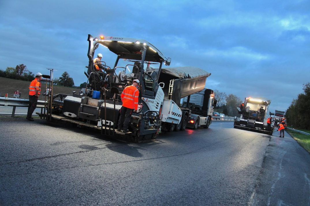 Workers applying Biophalt sustainable asphalt technology by Eiffage on a city road
